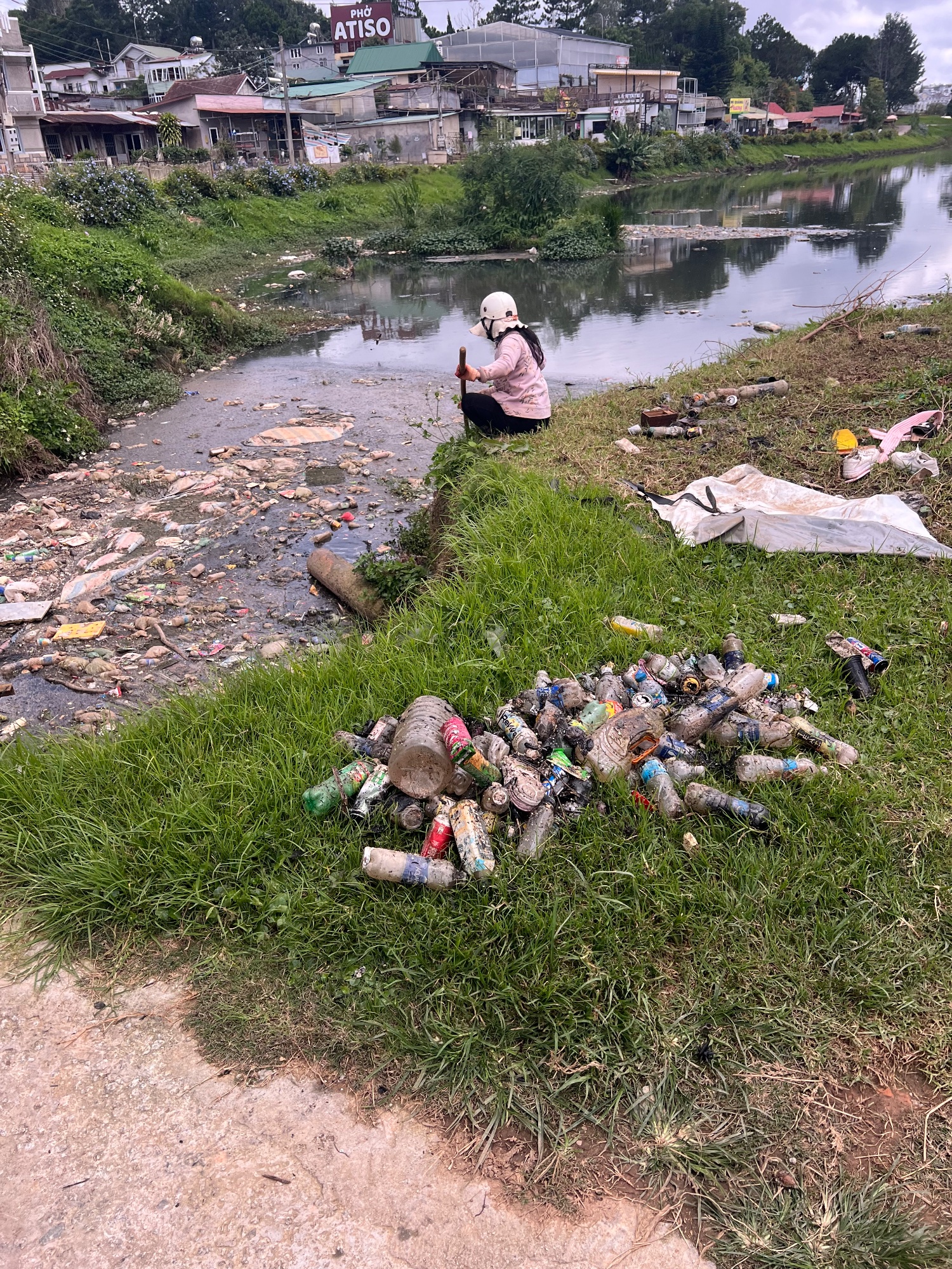 Poverty is still appaling. She fishes out the plastic bottles.