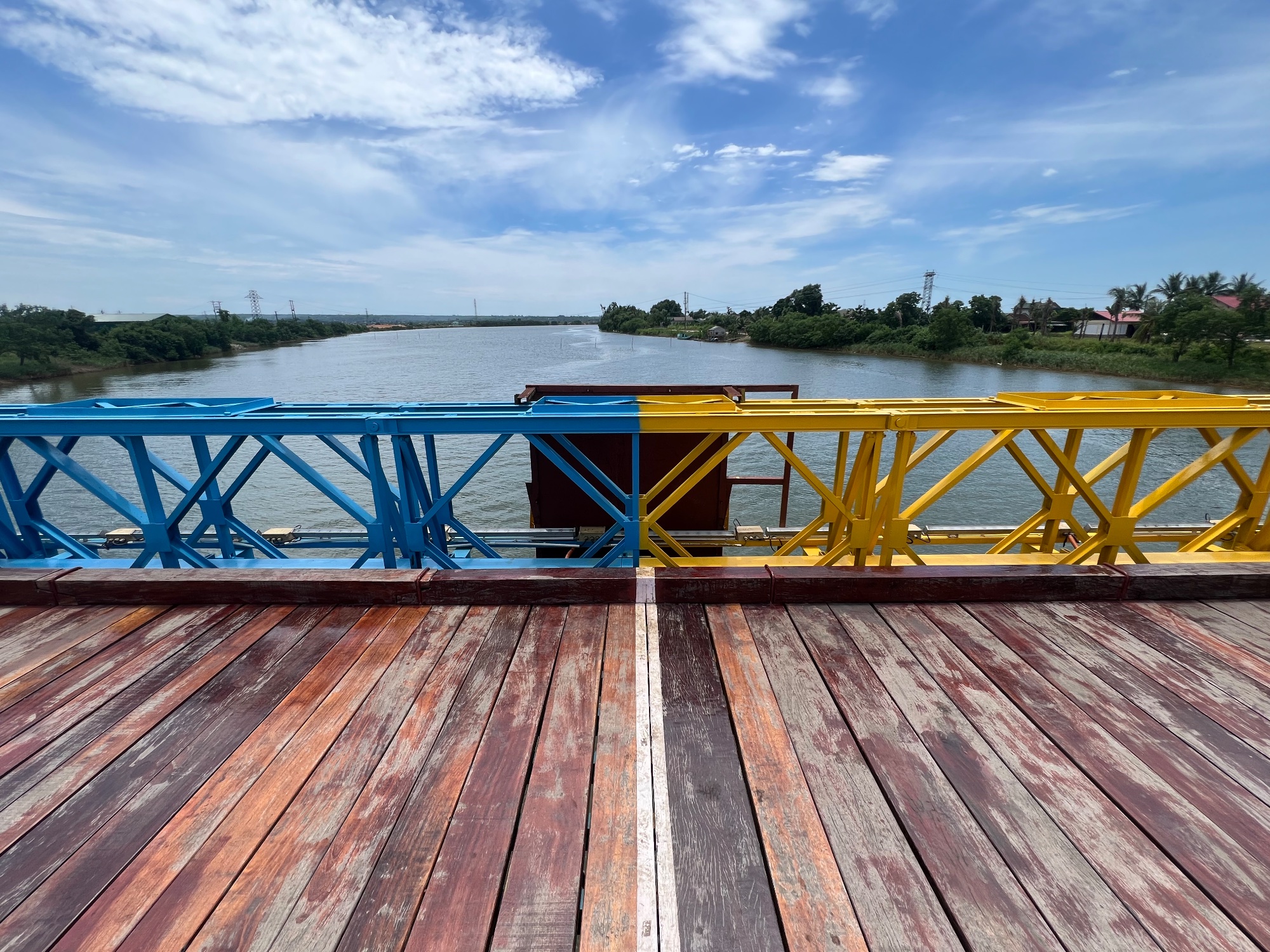 The story goes that south Vietnam always repainted their side of the bridge, with the Northern part following suit to paint theirs in the same color to emphasize the unity of the country. Current color combination appears very peculiar. 
